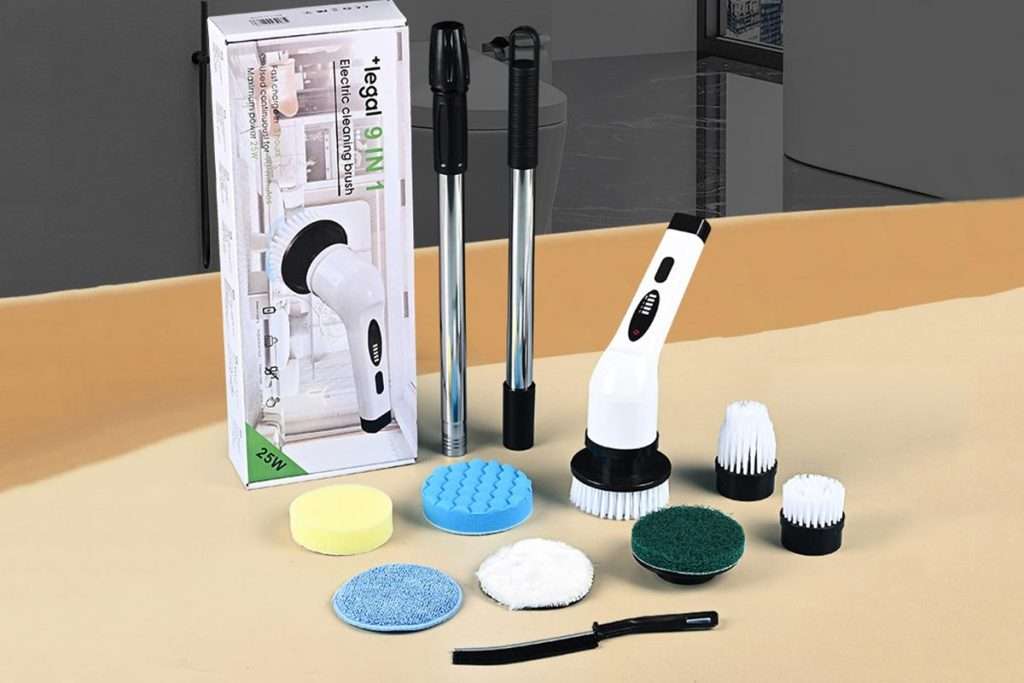 Electric scrubber with its box and cleaning attachments displayed on a table